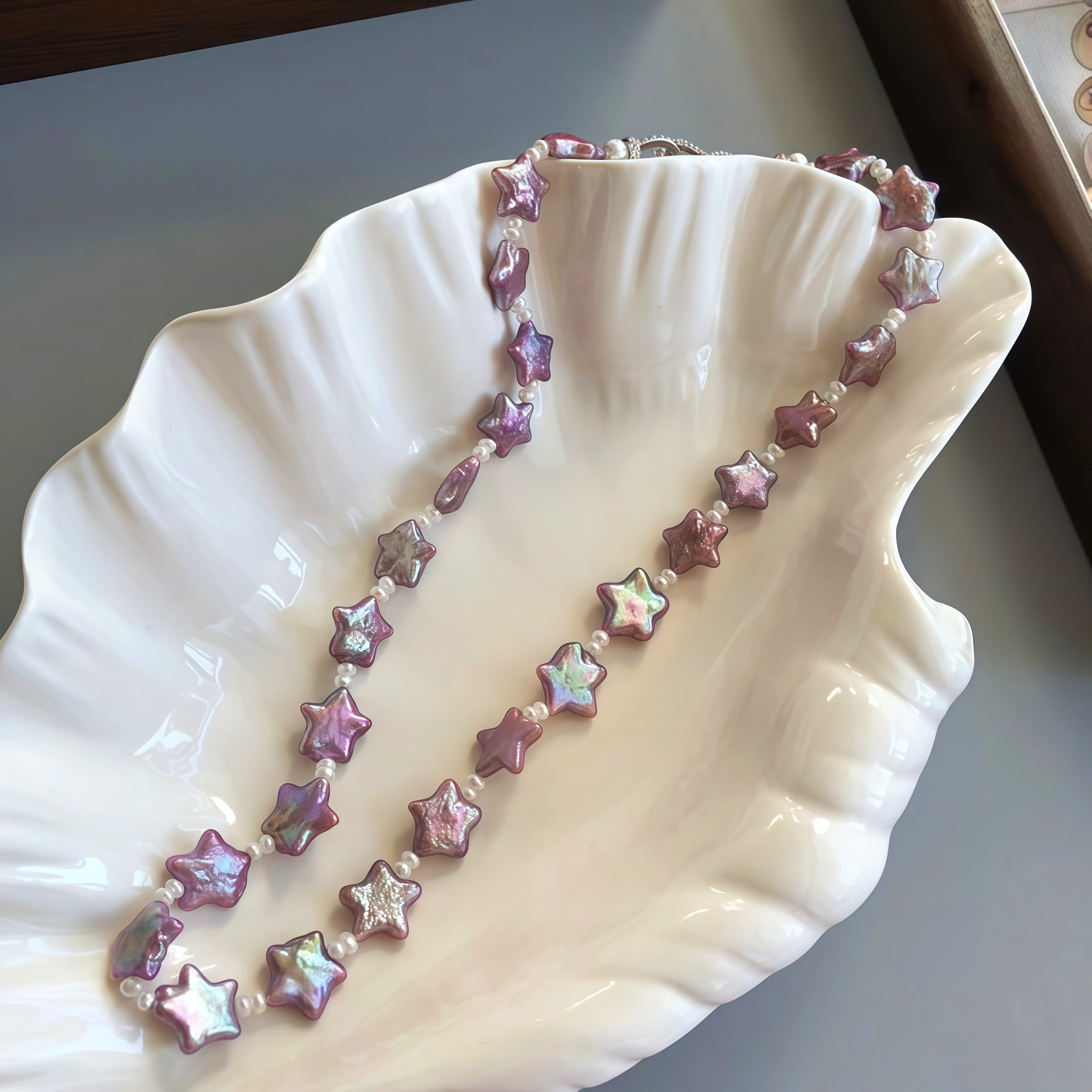 Star pearl necklace purple color on a white plate