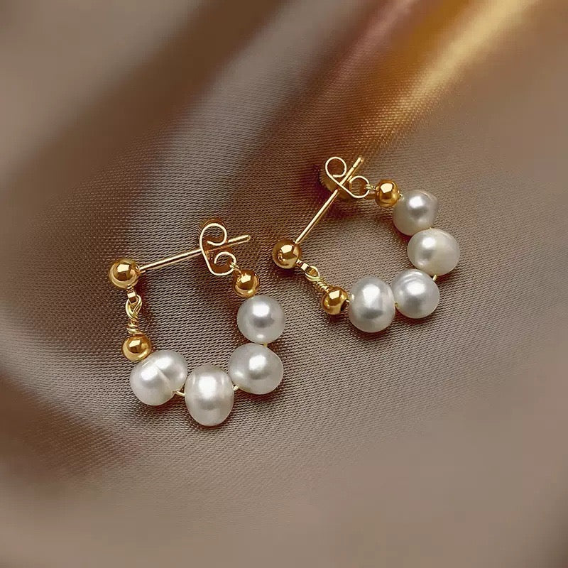 Close-up of high-luster 5–6mm freshwater pearls on minimalist sterling silver earrings