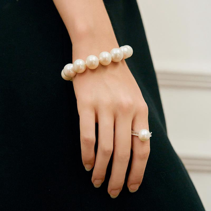 igh-luster pearl bracelet styled with gold rings on hand – fine jewelry look