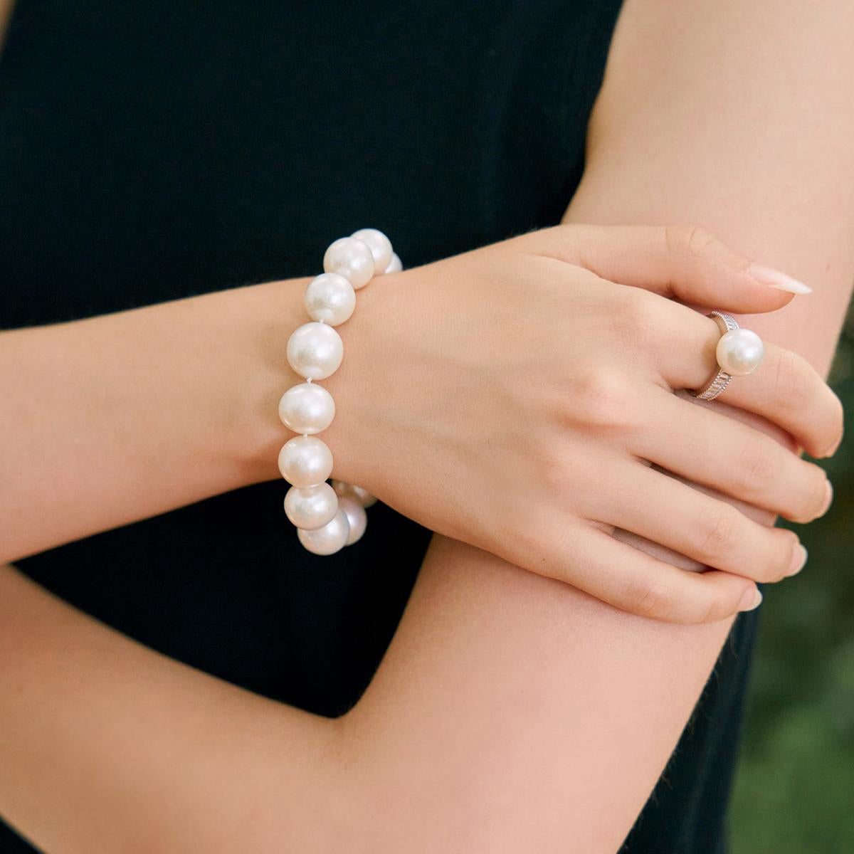 igh-luster pearl bracelet styled with gold rings on hand – fine jewelry look