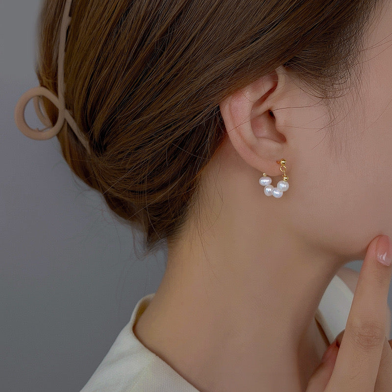 Model wearing 5–6mm freshwater pearl earrings in a small hoop style for everyday wear