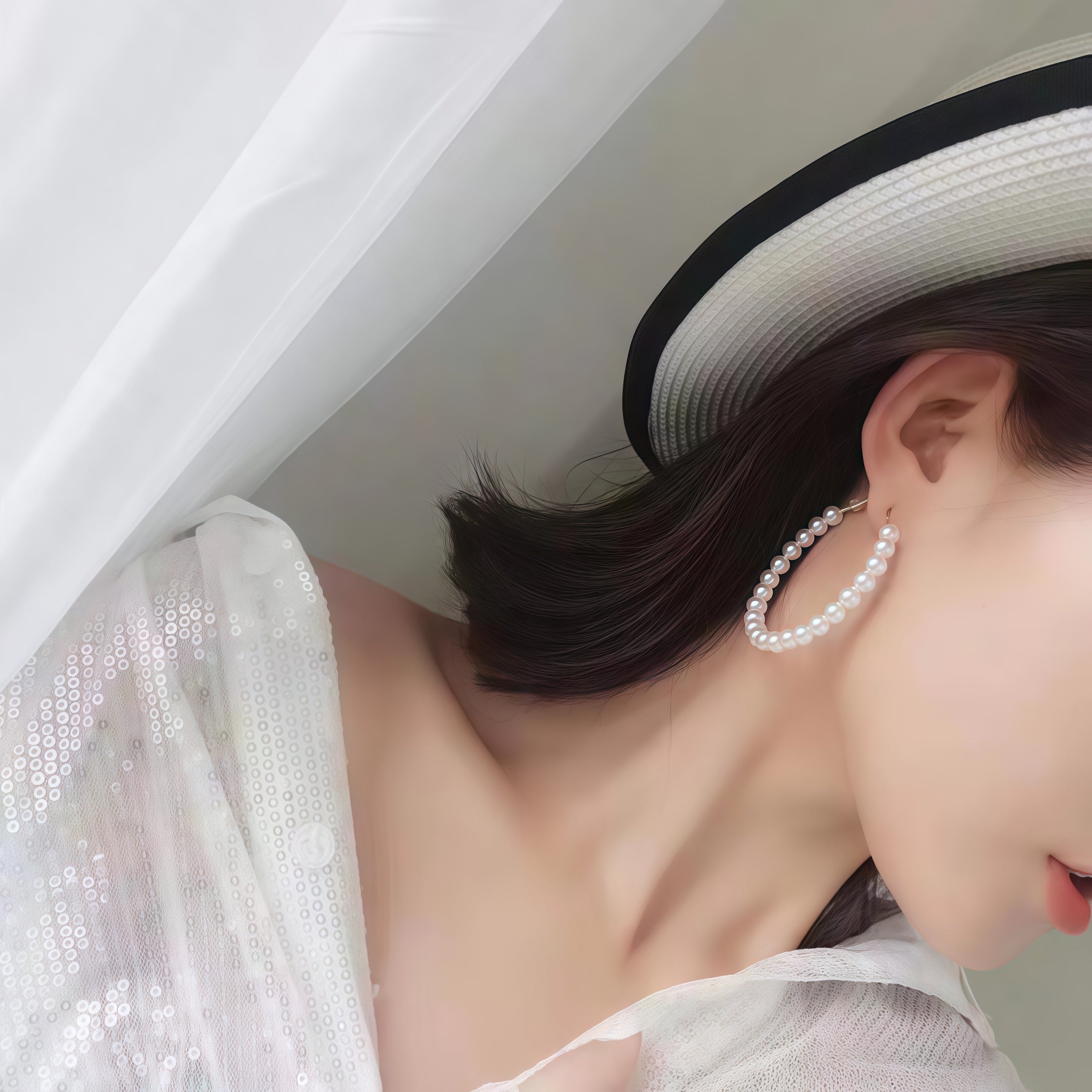 Side view of model wearing large freshwater pearl hoop earrings with high-luster white rice pearls